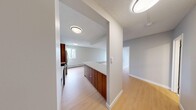 Located in Calgary, AB, this 1-bedroom, 1-bathroom unit offers a thoughtfully designed layout across a single floor. Light hardwood flooring flows throughout the space, lending a clean and cohesive aesthetic.

The kitchen is a standout feature, showcasing a striking contrast of rich walnut-toned lower cabinetry paired with crisp white upper cabinets. Stainless steel appliances — including a refrigerator, electric range, and built-in microwave hood — complement the white quartz peninsula countertop, which provides additional prep space and separates the kitchen from the open living area. White subway tile backsplash adds a modern touch, while a window brings in natural light.

The living area is spacious and bright, with a large sliding window offering views of the surrounding Calgary cityscape. Baseboard heating runs along the walls, ensuring year-round comfort.

The bedroom is a comfortable, well-sized retreat with its own window overlooking the urban surroundings, providing ample natural light. The neutral grey wall tones throughout the unit create a calm, versatile backdrop. A textured ceiling adds subtle architectural detail, completing this functional and modern urban residence.