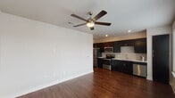 Located in the Lincoln Heights neighborhood of Houston, TX, this single-story unit offers a thoughtfully designed open-concept layout with consistent wood-look flooring throughout. The living area is spacious and airy, featuring neutral-toned walls, recessed lighting, and a ceiling fan that enhances comfort and airflow. The open sightlines connect the living space directly to the kitchen, creating a cohesive, functional environment.

The kitchen is well-appointed with dark espresso cabinetry extending to the upper walls, providing generous storage. Stainless steel appliances—including a refrigerator, range, built-in microwave, and dishwasher—complement the crisp white countertops. A tile backsplash in a soft gray tone adds a subtle design accent, while the undermount stainless steel sink with a modern faucet completes the space.

The bedroom is a well-proportioned room featuring the same warm wood-look flooring, a ceiling fan, and a large window dressed with horizontal blinds that allows ample natural light to fill the room.

The bathroom includes a full soaking tub and shower combination with a curved curtain rod, set against clean white walls, continuing the unit's clean and contemporary aesthetic throughout.