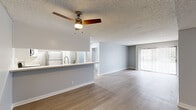 Located on Blix Street in the North Hollywood neighborhood of Los Angeles, this 2-bedroom, 2-bathroom single-floor unit offers a clean, functional layout with a neutral color palette throughout. Light wood-style flooring runs continuously across the living areas and bedrooms, complemented by soft gray walls and white trim that give the space a bright, cohesive feel.

The open living area is anchored by a ceiling fan and receives natural light through a large sliding glass door fitted with vertical blinds, which opens to an outdoor view. Adjacent to the living space, the kitchen features a pass-through counter with a light stone-toned surface, stainless steel appliances including a gas range, microwave, and refrigerator, along with an in-unit stacked washer and dryer.

Both bedrooms are comfortably proportioned, with the primary bedroom offering generous space, large windows with vertical blinds, and access to natural light. The second bedroom features a wide window overlooking the exterior. Each room benefits from the same light flooring and neutral tones found throughout.

The two bathrooms are identically appointed with white cabinetry, stone-toned countertops, large mirrors, and a tub-shower combination with brushed nickel fixtures. Textured ceilings are present throughout the unit, adding a consistent architectural detail to every room.