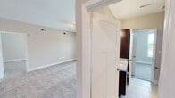 Located on E Revere Blvd in Huntsville, Alabama, this single-story home offers a well-designed layout with a cohesive neutral color palette throughout. The kitchen serves as a standout feature, showcasing dark espresso cabinetry, granite countertops, a white subway tile backsplash, and stainless steel appliances including a refrigerator, electric range, and built-in microwave. A central island with a double-basin sink and pendant lighting overhead adds both functionality and style, while warm hardwood-style flooring completes the space.

The bedrooms are finished with plush carpeting and feature ceiling fans with lighting. Generous natural light enters through windows with outdoor views of the surrounding neighborhood. Multiple doorways lead to well-appointed bathrooms, each featuring tile flooring, granite-topped dark vanities, and a tub-shower combination with built-in shelving. Brushed nickel hardware and grab bars add practical detail throughout.

A dedicated laundry room with hardwood-style flooring houses a full-size washer and dryer with overhead shelving. White panel doors, clean white trim, and consistent neutral wall tones lend the home a cohesive, move-in-ready appeal.