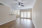 Located at 344 Murray Farm Dr in Fairview, TX, this single-story, one-bedroom, one-bathroom home offers a well-designed layout with comfortable living spaces throughout. The open-concept living, dining, and kitchen area serves as the heart of the home, featuring rich hardwood-style flooring, crown molding, and a ceiling fan with a light fixture. French doors flood the living area with natural light and provide a welcoming focal point. The kitchen is well-appointed with dark espresso cabinetry, dark granite-style countertops, a tile backsplash, black appliances including a range and built-in microwave, a double basin sink, and pendant lighting overhead. A pantry provides additional storage convenience. The bedroom is a comfortable retreat finished with plush carpet, crown molding, and a ceiling fan. Two closets, including a walk-in with wire shelving, offer generous storage. The full bathroom features tile flooring, a dark vanity, and a bathtub. A dedicated laundry room with side-by-side washer and dryer hookups and a separate utility room add practical functionality. The warm, neutral color palette and consistent finishes throughout create a cohesive and inviting atmosphere.