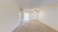 Located at 135 Sharene Ln in Walnut Creek, California, this single-floor residence offers a clean, neutral palette throughout, creating a bright and functional living environment. The spacious living area is finished with plush wall-to-wall carpeting and features a ceiling fan with integrated lighting. Smooth white walls and natural light from plantation-shuttered windows contribute to an open, airy atmosphere, while a wall-mounted HVAC unit provides climate control. The kitchen is outfitted with white cabinetry, light stone-look countertops, and white appliances including an electric range, refrigerator, and dishwasher. Tile flooring runs throughout the kitchen and adjacent areas, and a sliding glass door opens directly to a private outdoor patio, bringing in abundant natural light and providing convenient outdoor access. The bedroom is generously proportioned with soft carpeting, a large sliding-door closet with a full-length hanging rod, and a louvered window for natural ventilation. The bathroom is finished in crisp white tile and includes a tub/shower combination, toilet, and vanity. Overall, the space presents a straightforward, well-maintained layout suited for comfortable single-floor living in the heart of Walnut Creek.