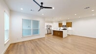 Located at 54 Aruba Bend Dr in Katy, TX, this modern single-story home offers a well-designed layout across five bedrooms and three bathrooms. The open-concept kitchen and living area serves as the heart of the home, showcasing light wood-tone flooring, recessed lighting, and a sleek ceiling fan. The kitchen is outfitted with a striking two-tone cabinetry design — combining crisp white upper cabinets with warm wood lower cabinets — topped with quartz countertops featuring subtle veining. A central island with an integrated sink and matching quartz surface adds both functionality and style, complemented by stainless steel appliances. The bedrooms are bright and airy, each featuring light hardwood-style flooring, white walls, and windows with blinds that allow natural light to filter in. The spacious primary bedroom includes a ceiling fan and multiple windows. The primary bathroom features elegant marble-style tile walls and flooring, with a glass-enclosed walk-in shower and matte black fixtures. A dedicated walk-in closet provides ample built-in shelving and hanging space. The laundry room comes equipped with a full-size washer and dryer. The attached two-car garage offers generous space with an automatic opener. Clean finishes and a neutral palette create a cohesive, contemporary feel throughout.