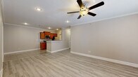 This single-story home in North Little Rock, Arkansas offers a well-designed layout with a seamless flow between living spaces. The open-concept living and dining area features light-toned laminate wood flooring, crown molding, recessed lighting, and a ceiling fan, creating a bright and airy atmosphere. A marble-surround fireplace serves as a focal point in the main living room, which also features access to the outdoors through sliding glass doors fitted with blinds.

The kitchen is equipped with warm-toned wood cabinetry, granite countertops, stainless steel appliances including a range, microwave, refrigerator, and dishwasher, and a peninsula that connects to the living area. Granite tile flooring ties the kitchen aesthetic together cohesively.

The bedrooms feature the same light laminate flooring, ceiling fans, and neutral wall tones, with at least one bedroom offering a walk-in closet. The bathrooms are finished with granite tile flooring and surfaces, including a full bath with a tub and floor-to-ceiling granite tile surround, and a secondary bath with a wood vanity and granite countertop. Crown molding and consistent neutral tones throughout give the home a clean, unified appearance.