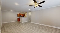 This single-story home in North Little Rock, Arkansas offers a well-designed layout with a seamless flow between living spaces. The open-concept living and dining area features light-toned laminate wood flooring, crown molding, recessed lighting, and a ceiling fan, creating a bright and airy atmosphere. A marble-surround fireplace serves as a focal point in the main living room, which also features access to the outdoors through sliding glass doors fitted with blinds.

The kitchen is equipped with warm-toned wood cabinetry, granite countertops, stainless steel appliances including a range, microwave, refrigerator, and dishwasher, and a peninsula that connects to the living area. Granite tile flooring ties the kitchen aesthetic together cohesively.

The bedrooms feature the same light laminate flooring, ceiling fans, and neutral wall tones, with at least one bedroom offering a walk-in closet. The bathrooms are finished with granite tile flooring and surfaces, including a full bath with a tub and floor-to-ceiling granite tile surround, and a secondary bath with a wood vanity and granite countertop. Crown molding and consistent neutral tones throughout give the home a clean, unified appearance.