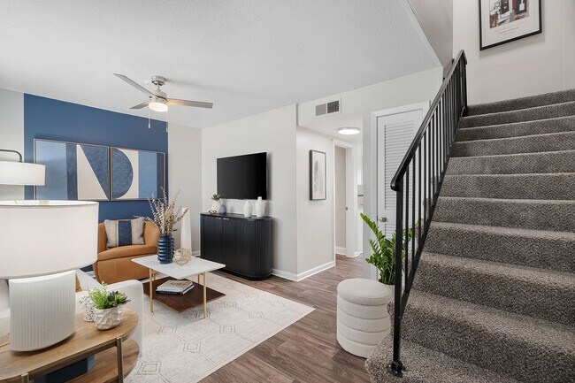 Sala de estar con piso estilo madera y ventilador de techo. - Blakely