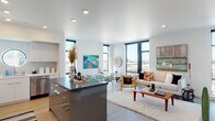 Located at 2680 Shattuck Ave in Berkeley, California, this modern single-floor residence offers a thoughtfully designed open-concept layout with clean lines and a bright, contemporary aesthetic throughout. The expansive living and dining area is anchored by large, black-framed windows that flood the space with natural light and frame views of the surrounding Berkeley cityscape and hills. Light hardwood flooring runs throughout the main living areas, complementing the crisp white walls and recessed lighting overhead. The kitchen is a standout feature, outfitted with sleek high-gloss white cabinetry, stainless steel appliances, a subway tile backsplash, and a bold grey island with bar seating — a distinctive architectural porthole window adds a unique design touch. The bedrooms offer plush carpeting, generous proportions, and tranquil corner window views. Bathrooms are finished in clean, modern white with a full tub and shower combinations. A well-proportioned hallway with hardwood floors and framed artwork connects the private quarters to the main living spaces, maintaining a cohesive and polished flow throughout. The residence presents a refined urban living experience in the heart of Berkeley.