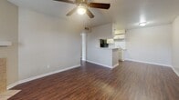 Located at 11910 Thoroughbred Dr in Houston, TX, this single-story unit offers a practical and well-appointed layout designed for comfortable everyday living. The living area is open and airy, featuring rich dark hardwood-style flooring, neutral-toned walls, and a ceiling fan with integrated lighting. A half-wall peninsula seamlessly connects the living space to the kitchen, creating an open-concept flow ideal for entertaining or daily use. The kitchen is efficiently laid out in a galley style, showcasing white shaker-style cabinetry with brushed nickel hardware, a white subway tile backsplash, light countertops, and black appliances including a range, microwave, refrigerator, and dishwasher. A stainless steel sink with a modern faucet rounds out the functional workspace. The bedroom features plush wall-to-wall carpeting, a ceiling fan, and a charming curved bay window that invites natural light and adds architectural character. An additional room with carpeting provides flexible space for various uses. The bathroom is clean and well-organized, with a full tub and shower combo framed by white tile, white cabinetry for storage, and the same dark hardwood-style flooring found throughout the main living areas. The consistent neutral palette and updated finishes throughout create a cohesive, move-in-ready environment.