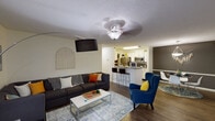 This single-story residence offers a thoughtfully designed layout with a seamless flow between living spaces. The open-concept living room is a welcoming area finished with wood-look flooring, a textured ceiling, and ceiling fan. Large windows dressed with floor-length curtains bring in natural light, while the space comfortably accommodates a full seating arrangement. The living area opens directly to the kitchen, which features white cabinetry, granite-style countertops, stainless steel appliances including a refrigerator, microwave, and range, and a breakfast bar with counter seating — ideal for casual dining.

The bedrooms are carpeted and each includes a ceiling fan, natural light from windows, and ample room for a full furniture arrangement. One bedroom benefits from a walk-in closet with wire shelving and hanging space for generous storage. Two full bathrooms serve the unit, each with a tub-shower combination, wood-look flooring, and a vanity with storage. The overall design is clean and functional, with neutral tones throughout that create a bright, cohesive atmosphere across every room.