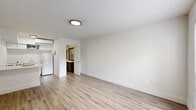 Located at 2900 Bird Ave in Miami's vibrant Coconut Grove neighborhood, this single-floor unit offers a clean, modern aesthetic with an efficient and well-organized layout. The interior is finished with light wood-look laminate flooring throughout the main living area, which lends a bright and airy feel to the space. Neutral white walls and flush-mount ceiling lighting create a crisp, minimalist atmosphere that maximizes the sense of openness.

The living area serves as the central hub of the unit, with a large window dressed with horizontal blinds allowing natural light to filter in and offering greenery views outside. A light gray entry door adds a subtle design accent. A wall-mounted mini-split HVAC unit ensures climate control comfort year-round.

The kitchen is integrated into the layout and features white appliances, including a full-size refrigerator, providing functional everyday amenities in a compact footprint.

Two bathrooms serve the unit, one of which is notably well-appointed with a wide, dark wood vanity topped with a white countertop, a large framed mirror, tile flooring, and a grab bar — reflecting thoughtful, accessible design. The bathroom connects directly back to the main living area, contributing to the unit's practical flow.

Overall, the space presents a clean, move-in-ready environment with modern finishes in one of Miami's most sought-after neighborhoods.