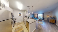 Located in Salem, MA, this thoughtfully designed one-bedroom, one-bathroom residence offers a functional and stylish single-floor layout. The open-concept kitchen flows seamlessly into the living area, centered around a granite-topped peninsula with bar seating — ideal for casual dining or entertaining. The kitchen is fully equipped with stainless steel appliances, including a refrigerator, range, microwave, and dishwasher, complemented by gray shaker-style cabinetry and light wood-look flooring. A dedicated dining nook adjacent to the kitchen provides an additional space for meals. The living room is generously proportioned, featuring sliding glass doors that flood the space with natural light and open to a private outdoor area. The bedroom offers plush carpeting, a large window with ample natural light, and room for a desk or workspace. The bathroom features a granite-topped vanity with gray cabinetry, a large mirror, and tile flooring, maintaining the consistent, modern aesthetic found throughout the home. Neutral tones and contemporary finishes create a cohesive, welcoming atmosphere throughout this well-designed residence.
