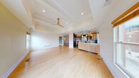 Located in the heart of Springfield, MO, this two-story residence offers a thoughtfully designed layout across two floors, with the main level comprising the vast majority of the living space. The grand entry hallway makes an immediate impression with its striking black-and-white marble checkerboard tile flooring and transom-topped doorways leading into the formal living room, which features polished hardwood floors, elegant coffered ceilings, decorative columns, and sage-green accent walls bathed in natural light from large windows. The open-plan living and dining area continues this refined aesthetic, showcasing a tray ceiling with a contemporary ceiling fan and seamless flow into the kitchen. The kitchen is equipped with light maple cabinetry with glass-front upper doors, sleek countertops, stainless steel appliances, a built-in window seat, and a center island. The generously sized primary bedroom features tray ceilings, a ceiling fan, and multiple windows overlooking the surroundings, complemented by a well-organized closet with adjustable shelving systems. Bathrooms offer distinctive finishes, including one with floor-to-ceiling green mosaic tile and a wall-mounted toilet. The dedicated laundry room includes a washer and dryer, granite countertops, a utility sink, and ample cabinetry. A patio, two staircases, and additional storage complete this impressive residence.