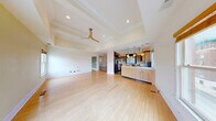 Located in the heart of Springfield, MO, this two-story residence offers a thoughtfully designed layout across two floors, with the main level comprising the vast majority of the living space. The grand entry hallway makes an immediate impression with its striking black-and-white marble checkerboard tile flooring and transom-topped doorways leading into the formal living room, which features polished hardwood floors, elegant coffered ceilings, decorative columns, and sage-green accent walls bathed in natural light from large windows. The open-plan living and dining area continues this refined aesthetic, showcasing a tray ceiling with a contemporary ceiling fan and seamless flow into the kitchen. The kitchen is equipped with light maple cabinetry with glass-front upper doors, sleek countertops, stainless steel appliances, a built-in window seat, and a center island. The generously sized primary bedroom features tray ceilings, a ceiling fan, and multiple windows overlooking the surroundings, complemented by a well-organized closet with adjustable shelving systems. Bathrooms offer distinctive finishes, including one with floor-to-ceiling green mosaic tile and a wall-mounted toilet. The dedicated laundry room includes a washer and dryer, granite countertops, a utility sink, and ample cabinetry. A patio, two staircases, and additional storage complete this impressive residence.