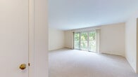 Located at Heritage Circle in Madison, WI, this well-appointed 3-bedroom, 2-bathroom single-floor residence offers a comfortable and functional layout. The spacious living room features soft carpeting, neutral tones, and a sliding glass door that opens onto a private white-railed balcony overlooking a lush, tree-lined landscape — an inviting extension of the living space. An elegant chandelier anchors the dining area, which flows seamlessly from the living room. The kitchen is well-equipped with white cabinetry, light hardwood flooring, stainless steel appliances including a refrigerator, range with over-the-range microwave, and dishwasher, all complemented by clean white countertops. The generously sized primary bedroom provides ample space for a full suite of furniture, while the additional bedrooms offer carpeted floors and built-in closet storage. The bathrooms are finished with white tile, white cabinetry with silver hardware, and large mirrors above the vanities. A hallway and dedicated closet space provide practical storage throughout. The home's warm, neutral palette and natural light create a bright, welcoming ambiance throughout.