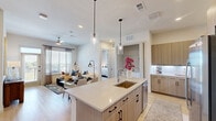 Located at 1345 14th St in Plano, TX, this well-appointed 2-bedroom, 2-bathroom residence offers a thoughtfully designed single-floor layout with modern finishes throughout. The open-concept living, dining, and kitchen area serves as the heart of the home, anchored by light hardwood flooring, recessed lighting, and large windows that invite abundant natural light. The kitchen is outfitted with stainless steel appliances, sleek light wood cabinetry, a white quartz countertop, and a generous island with bar seating — ideal for both cooking and casual dining. A dedicated laundry area is conveniently accessible from the kitchen. The dining space comfortably accommodates a full-sized table, complemented by modern pendant lighting overhead. Both bedrooms feature plush carpet, ceiling fans, and large windows with outdoor views. The spacious primary bedroom connects to a well-designed en-suite bathroom featuring gray cabinetry, a white quartz vanity, and a walk-in marble-tiled shower. The second bathroom mirrors the same refined aesthetic with dual vanity storage and clean tile flooring. Each bedroom is served by a dedicated walk-in closet equipped with multi-tier shelving and hanging systems. The overall ambiance is clean, contemporary, and inviting — a refined space suited for comfortable everyday living.