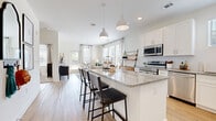 Located at 13511 Montoy Way in Charlotte, NC, this well-appointed one-bedroom, one-bathroom home offers a thoughtfully designed single-floor layout. The open-concept kitchen and living area serves as the heart of the home, featuring white shaker cabinetry, granite countertops, a center island with bar seating, stylish pendant lighting, and a full suite of stainless steel appliances. Light wood-tone flooring runs throughout, complementing the bright, airy feel created by large windows and a glass patio door that flood the living space with natural light and outdoor views.

The living room provides a comfortable retreat with multiple windows framing lush greenery outside. The bedroom is a serene space with plush carpet, a ceiling fan, and a natural color palette, offering a calm and restful atmosphere. The spacious walk-in closet includes built-in wire shelving and ample hanging space for organized storage.

The full bathroom is well-appointed with a granite-topped vanity, wood-tone flooring, a large mirror with modern lighting, and a shower-tub combination. Clean white walls and consistent finishes throughout the home create a cohesive, modern aesthetic that is both functional and inviting.