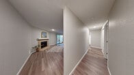 Located at 14820 Redmond Way in Redmond, WA, this two-bedroom, two-bathroom single-floor residence offers a well-organized layout with consistent wood-style flooring flowing throughout. The living room serves as a central gathering space, anchored by a tile-surround fireplace with a clean white mantle and access to a sliding glass door that brings in natural light. Adjacent, the dining area features a ceiling fan and connects seamlessly to the galley-style kitchen, which is outfitted with stainless steel appliances including a gas range, refrigerator, and dishwasher, complemented by two-tone cabinetry — white uppers and warm gray lowers — with quartz countertops and a subway tile backsplash. A hallway leads to both bedrooms, each finished with the same wood-style flooring and neutral wall tones. The spacious primary bedroom includes a sliding closet and natural light from a window. The second bedroom offers a similarly bright and clean feel. Both bathrooms are finished with modern dark-wood vanities, quartz countertops, and textured walls. The overall aesthetic is clean, neutral, and move-in ready, making efficient use of the available space.