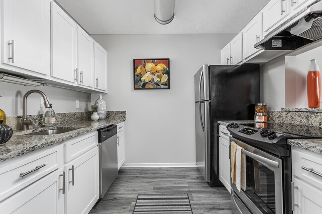 Kitchen with Stainless Steel Appliances and Granite Countertops - The Pointe at Canyon Ridge Apartments