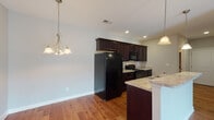 Located at 4159 Reserve Rd in Lexington, Kentucky, this single-floor home offers a thoughtfully designed layout that balances functionality with comfort. The kitchen serves as a central highlight, featuring rich dark wood cabinetry, granite-style countertops, a tile backsplash, and black appliances including a range, microwave, and refrigerator. A peninsula with a double stainless steel sink and pendant lighting adds both workspace and a casual dining element, while warm hardwood flooring ties the kitchen and adjoining living areas together seamlessly. Recessed lighting and a decorative chandelier provide ample illumination throughout. The bedrooms are finished with plush carpeting and neutral gray-toned walls, creating a calm and restful atmosphere. Each bedroom features windows that invite natural light and offer views of the surrounding neighborhood. Closets with bifold doors provide organized storage. Both bathrooms are consistently styled with dark wood vanities, granite-topped counters, tile flooring, and tub-shower combinations, offering a clean and cohesive look. The overall design of the home emphasizes a neutral, move-in-ready aesthetic with consistent finishes throughout, making it a practical and comfortable residence in the Reserve Road community of Lexington.