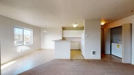 Located at 620 NE Kamiaken Street in Pullman, Washington, Unit B301 is a single-floor residence thoughtfully designed for comfortable everyday living. The open-concept layout connects the living area to the kitchen, creating a cohesive and functional shared space. The living room features neutral-toned carpet and a pendant light fixture, with a window that allows natural light to fill the room. Adjacent to the living area, the kitchen is defined by a peninsula counter that provides both workspace and a casual dining option. White cabinetry offers generous storage, while a tile floor, fluorescent overhead lighting, a range, and a refrigerator complete the functional setup. The bedrooms are carpeted and feature soft, neutral walls. One bedroom includes a window with a view of the surrounding natural landscape and a baseboard heater, while another offers a walk-in closet for added storage. The bathroom is well-appointed with a tub-shower combination, a vanity with ample counter space, a large mirror, and tile flooring. Throughout the unit, the clean, light color palette and consistent finishes create a calm and practical living environment well-suited for Pullman residents.