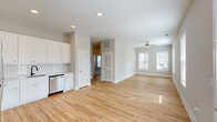 Located at 1477 Springvale Hill Dr in Kernersville, NC, this well-appointed 2-bedroom, 3-bathroom single-floor home offers a clean, modern design throughout. The open-concept layout seamlessly connects the kitchen and living room, creating a bright and functional shared space. Light hardwood flooring flows throughout the main living areas, complemented by neutral gray-toned walls and an abundance of natural light from multiple windows fitted with blinds. Ceiling fans in both the living room and primary bedroom add comfort and airflow.

The kitchen is thoughtfully designed with white shaker-style cabinetry extending to the ceiling, a classic subway tile backsplash, white countertops, and a full suite of stainless steel appliances including a refrigerator, range, microwave, and dishwasher. The living room is generously proportioned, bathed in natural light from a bank of windows.

Both bedrooms feature plush carpeting and ceiling fans. The primary bedroom includes a dedicated walk-in closet outfitted with wire shelving for organized storage. The bathrooms are finished with white vanities, clean countertops, and tile flooring. The overall aesthetic is bright, clean, and move-in ready, offering a comfortable and practical living environment.
