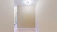 Located in the heart of Hollywood at 7275 Franklin Ave, this 2-bedroom, 2-bathroom residence offers a well-designed single-floor layout with a clean, neutral aesthetic throughout. The open kitchen and living area serves as the heart of the home, where the living room features light hardwood-style tile flooring, recessed lighting, a ceiling fan, and a classic white fireplace as a central focal point. The kitchen is appointed with steel-blue shaker cabinetry, a mosaic tile backsplash, white quartz countertops, a stainless steel sink with gold-toned fixtures, and stainless steel appliances, all illuminated by a large window. A central hallway connects the living spaces to the private quarters, accented with modern loop-style ceiling lighting and warm beige walls. Both bedrooms feature plush carpeting and large windows that invite natural light and outdoor views. The spacious primary bedroom includes an en-suite bathroom and generous closet space. Both bathrooms are finished with white tile, marble-look flooring, and clean modern fixtures, including tub-shower combinations. Five closets throughout the unit provide ample storage, completing this well-appointed Los Angeles residence.