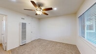 Located at 3949 Kansas Street in San Diego's vibrant North Park neighborhood, this efficient single-floor studio offers a thoughtfully arranged layout comprising a combined kitchen and living area, a bathroom, and a closet. The main living space features warm, neutral-toned carpet that adds comfort underfoot, while a ceiling fan with a light fixture provides both air circulation and ambient lighting, complemented by recessed ceiling lights. A wall-mounted HVAC unit ensures year-round climate control. Natural light filters in through a sizable window fitted with blinds, offering a pleasant view of the surrounding greenery. The kitchen area is neatly integrated along one wall, featuring light wood-tone flooring, white cabinetry, a built-in countertop with a stainless steel sink, a stainless steel refrigerator, and a rustic wooden wall shelf with hooks — ideal for compact, efficient living. The bathroom is finished with the same warm wood-tone flooring and includes a toilet, vanity with sink, and a frosted window that provides natural light while maintaining privacy. The clean white walls throughout create a bright, open atmosphere, making this a practical and comfortable space in one of San Diego's most walkable urban neighborhoods.