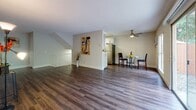 This single-floor residence offers a thoughtfully designed layout that balances open living spaces with functional private areas. Rich, dark hardwood-style flooring runs throughout, providing a cohesive and polished look from room to room.

The main living area is generously proportioned, featuring a textured ceiling and large sliding glass doors that flood the space with natural light while offering direct views of lush, mature greenery outdoors. The open flow connects seamlessly to a dedicated dining area, which is accented by a ceiling fan and sits adjacent to the kitchen.

The kitchen is well-equipped with white shaker-style cabinetry, white quartz countertops, and a full suite of stainless steel appliances including a gas range, microwave, and refrigerator. A skylight adds additional brightness to the workspace.

The bedrooms are bright and comfortable, each featuring hardwood-style flooring and ample closet space, including mirrored sliding-door closets in one room. Windows in the bedrooms frame views of the surrounding landscape, enhancing the sense of connection to the outdoors.

The bathroom is cleanly finished with white cabinetry, a vessel sink, quartz countertop, and a full tub-and-shower combination with tile surround. Throughout the residence, neutral tones and clean lines create a calm, inviting ambiance.