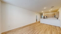 Located at 3055 Soldier City Way in Saint Cloud, Florida, this single-story, 3-bedroom, 2-bathroom home offers a clean, modern aesthetic throughout. Light-toned luxury vinyl plank flooring runs continuously across the entire floor plan, creating a cohesive and bright atmosphere in every room. The open kitchen and living area serves as the heart of the home, featuring a well-designed kitchen equipped with stainless steel appliances — including a refrigerator, range, over-the-range microwave, and dishwasher — complemented by sleek gray cabinetry, white quartz countertops, and recessed lighting. The three bedrooms are finished in the same warm, neutral palette with crisp white walls and ample natural light streaming through slatted window blinds. Each bedroom includes closet space, with bifold and sliding closet doors providing convenient storage. The primary bedroom offers a comfortable footprint with its own dedicated closet. Both bathrooms are outfitted with modern fixtures, light cabinetry with white countertops, and tub-shower combinations featuring built-in shelving. A connecting hallway provides smooth flow between the private and shared areas of the home. The overall design is clean, contemporary, and move-in ready.