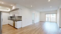Located in the vibrant Hollywood neighborhood of Los Angeles, this modern 3-bedroom, 2-bathroom single-story residence offers a thoughtfully designed open-concept layout. Light wood-tone flooring flows throughout, complementing the clean white walls and recessed lighting that create a bright, airy atmosphere across all living spaces.

The combined living and dining area is generously proportioned, offering a seamless connection to the galley-style kitchen. The kitchen is a standout feature, showcasing sleek white high-gloss cabinetry, dark quartz countertops, a herringbone tile backsplash, and a full suite of stainless steel appliances including a gas range, dishwasher, and French door refrigerator.

Three well-sized bedrooms provide comfortable accommodations, each benefiting from natural light through large windows. The primary bedroom features sliding glass doors that open directly onto a private patio, offering outdoor access and views of the surrounding neighborhood. Six closets distributed throughout the unit ensure ample storage.

Both bathrooms are finished to a contemporary standard, featuring large-format tile, sliding glass-enclosed tub-shower combinations, dark countertop vanities, and recessed lighting. A connecting hallway ties the layout together efficiently. The overall design is clean, modern, and move-in ready.