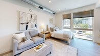 Located at 341 S Rio Grande St in Salt Lake City, Utah, this efficiently designed studio offers a thoughtfully organized single-floor layout that maximizes every square foot. Upon entering, a dedicated entrance hall leads into the main living area, where the space opens up to reveal a seamlessly integrated kitchen, living, and sleeping area bathed in natural light from large floor-to-ceiling windows overlooking the surrounding cityscape.

The kitchen is a standout feature, boasting a full suite of stainless steel appliances including a refrigerator, dishwasher, range, and built-in microwave. White cabinetry — both upper and lower — provides generous storage, complemented by open shelving and a sleek grey tile backsplash that adds a modern touch. Light wood-tone flooring runs throughout, lending warmth and continuity to the open-plan space.

The living and sleeping area is bright and versatile, with exposed ductwork adding an industrial-chic character. Recessed lighting supplements the abundant natural light. A full bathroom features a tub-shower combo with white tile surround, and the unit also includes an in-unit stacked washer and dryer for added convenience. Two closets offer practical storage solutions, completing this well-appointed urban studio.