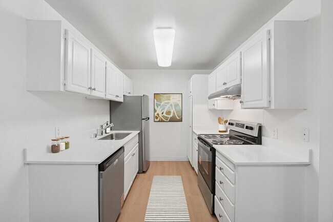 Paquete I de cocina renovada con gabinetes blancos, encimeras de cuarzo blanco, electrodomésticos de acero inoxidable y pisos de superficie dura. - eaves Foster City