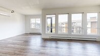 Located at 505 Broad Street in Halifax, Nova Scotia, this well-appointed two-bedroom, two-bathroom unit offers a thoughtfully designed single-level layout with generous living space. The open-concept kitchen and living room serve as the heart of the unit, featuring luxury vinyl plank flooring, white cabinetry, stainless steel appliances, a dark tile backsplash, and a central island with a built-in sink and pendant lighting. A wall of large windows in the living area floods the space with natural light and provides direct access to a private balcony with glass-railed decking and open views of the surrounding community. Both bedrooms are well-proportioned, with large windows, hardwood-style flooring, and access to ample closet space — including a walk-in closet with built-in shelving and hanging rods. The two bathrooms are finished with large-format tile flooring, modern white vanities with dark hardware, and tiled tub-shower surrounds. A dedicated in-unit laundry area houses a stacked Whirlpool washer and dryer. The overall palette of crisp white walls, neutral flooring, and clean-lined finishes creates a bright, contemporary ambiance throughout.