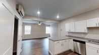 Located at 24 Eighth St N in Fargo, North Dakota, this single-floor unit offers a clean, modern aesthetic with a thoughtfully designed open-concept layout. Rich hardwood-style flooring flows seamlessly throughout the entire space, creating a cohesive and inviting atmosphere.

The kitchen is a standout feature, outfitted with crisp white shaker-style cabinetry, granite countertops, and a full suite of stainless steel appliances including a refrigerator, range, microwave, and dishwasher. A peninsula counter provides additional prep space and opens directly into the living area, making the layout ideal for both everyday living and entertaining.

The living area is generously sized, benefiting from natural light through multiple windows fitted with blinds. A ceiling fan adds both functionality and a finishing touch to the space. A wall-mounted ductless mini-split unit provides efficient climate control.

A well-organized closet with wire shelving offers practical storage solutions. The bathroom is neatly appointed with white cabinetry topped with granite countertops, a tub-shower combination, and consistent hardwood-style flooring. Recessed lighting throughout the unit contributes to a bright, polished interior. The overall design reflects a contemporary sensibility with durable, low-maintenance finishes.