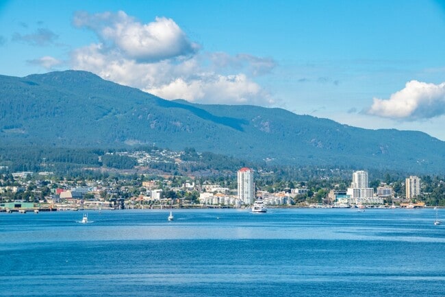 Scenic view of Nanaimo’s waterfront with mountains in the background.