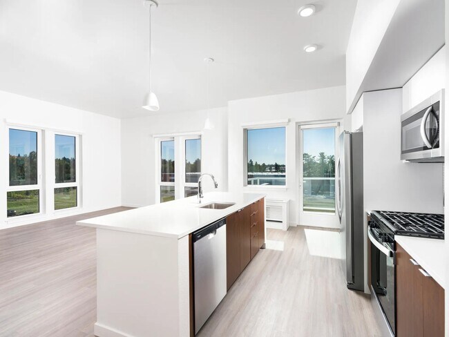 Este apartamento de concepto abierto cuenta con una cocina lista para chef con estufa a gas, elegantes electrodomésticos de acero inoxidable y espaciosos espacios de estar. - Modera Raleigh Hills