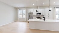 Located at 9 John St in Clinton, CT, this thoughtfully designed single-floor unit offers a clean, modern aesthetic with a bright and cohesive layout. Light-toned hardwood flooring runs throughout the space, creating a warm and continuous flow from room to room. The open-concept kitchen and living area serves as the heart of the unit, featuring white shaker cabinetry with matte black hardware, a center island with a white quartz countertop and undermount sink, stainless steel appliances including a French door refrigerator, gas range, and built-in microwave, plus a classic subway tile backsplash. Black pendant lights above the island add a stylish contrast to the bright, neutral palette. Recessed lighting and large windows allow natural light to fill the space, with views of the surrounding neighborhood. The spacious primary bedroom is a comfortable retreat, with recessed lighting, neutral walls, and a generous closet. The full bathroom is finished with large-format tile flooring, a white vanity with matte black fixtures, a framed mirror with overhead lighting, and a glass-enclosed tub and shower combination with tile surround. The overall ambiance is fresh, modern, and move-in ready, with a consistent design language carried throughout every room.
