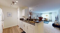 This one-bedroom, one-bathroom apartment at 150 Southfield Ave in Stamford, CT offers a well-designed, functional layout across a single floor. The open-concept kitchen features white cabinetry, dark granite countertops, a double-basin sink, and a peninsula breakfast bar that flows seamlessly into the living area. Wood-style flooring runs through the kitchen and hallway, while plush carpeting extends through the living room and bedroom. The living room is bright and welcoming, with large windows and sliding glass door access to a private balcony offering outdoor views. The spacious bedroom also opens to the balcony via its own sliding glass door, filling the room with natural light. A bold navy accent wall adds a distinctive design touch to the bedroom, which includes a generous walk-in closet with built-in shelving. The full bathroom is finished with wood-style flooring, white cabinetry, a well-lit vanity mirror, and a shower. A dedicated laundry area with a full-size washer and dryer provides added convenience. Additional hallway closet storage completes this thoughtfully appointed Stamford residence.
