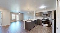 Located at 5024 Verdure Pkwy SE in Grand Rapids, Michigan, this one-bedroom, one-bathroom unit offers a well-designed layout with modern finishes throughout. The open-concept kitchen and living area form the heart of the space, anchored by a peninsula with a double stainless steel sink, crisp white countertops, and elegant pendant lighting above. The kitchen is equipped with dark espresso-toned cabinetry, a gas range, stainless steel microwave, dishwasher, and a full-size refrigerator, complemented by a subway tile backsplash for a clean, contemporary look. The living room extends naturally from the kitchen, featuring warm wood-style plank flooring, a ceiling fan, and a glass door with adjacent window that fills the space with natural light and provides outdoor views. The bedroom offers plush carpeting, a ceiling fan, and a window overlooking the greenery outside, creating a calm and comfortable retreat. The bathroom is finished with wood-style flooring, brushed nickel hardware, and a full tub-shower combination. A dedicated laundry room with wire shelving and a full-size washer and dryer adds everyday convenience. Neutral wall tones and consistent finishes give the unit a cohesive, move-in-ready feel throughout.
