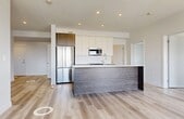 Located in the Edgemont community of Northwest Edmonton, this thoughtfully designed 3-bedroom, 2-bathroom unit offers a clean, modern aesthetic across a single floor. Light oak-toned laminate flooring flows throughout, complementing the bright white walls and creating a cohesive, contemporary feel.

The kitchen is a standout feature, showcasing two-tone cabinetry with dark wood-grain lower cabinets and crisp white uppers, paired with quartz countertops and a large central island. Stainless steel appliances, including a full-size refrigerator, built-in microwave, and dishwasher, complete the functional and stylish space.

Both bathrooms feature marble-look tile flooring and clean white fixtures. One bathroom includes a walk-in shower, while the other offers a soaking tub — both finished with wood-toned vanities and chrome hardware.

The three bedrooms are well-proportioned and bright, each receiving generous natural light through large windows. The primary bedroom benefits from sliding glass doors opening to a balcony with open views of the surrounding neighbourhood and natural landscape beyond.

A dedicated in-unit laundry closet with a stacked washer and dryer adds everyday convenience. The entrance provides a practical transition into the living areas, and a storage closet offers additional organizational space.