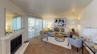 Located in Kent, Washington, this single-floor, two-bedroom, two-bathroom home offers a well-planned layout across a comfortable footprint. The inviting living room serves as the heart of the home, featuring a fireplace, plush carpeting, and large sliding glass doors that flood the space with natural light and open to a private patio overlooking lush greenery. The kitchen is outfitted with white cabinetry, light countertops, and wood-look flooring, providing a clean and functional workspace. The spacious primary bedroom accommodates generous furnishings and features a wide window with outdoor views, soft carpeting, and ample closet space. The second bedroom is versatile, with a large window that lets in natural light, making it equally suitable as a guest room or home office. Both bathrooms are well-appointed — one features a tub-shower combination, while the other includes a walk-in shower with clean white surround and chrome fixtures. A dedicated utility room houses a full-size side-by-side washer and dryer, adding everyday convenience. Two closets provide additional storage throughout the home. The hallway connects all rooms efficiently, contributing to the home's cohesive and functional flow.