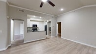 This single-story, 2-bedroom, 2-bathroom home offers a thoughtfully designed layout with a range of notable architectural features. Light-toned hardwood-style flooring runs throughout the main living areas, complemented by neutral gray walls and crisp white trim that create a clean, cohesive aesthetic.

The open living area is anchored by a tile-surround fireplace and features vaulted ceilings with crown molding and a ceiling fan, while multiple windows invite natural light and outdoor views. An arched passageway connects the living space to the kitchen, which is equipped with white cabinetry, dark granite countertops, black appliances, and a mosaic tile backsplash in earthy tones.

The primary bedroom is generously sized with vaulted ceilings, a ceiling fan, and a large arched window that floods the room with natural light. The second bedroom similarly benefits from vaulted ceilings and good natural light. Both bathrooms are finished in neutral tones, with one featuring a tiled tub-shower surround and white vanity cabinetry. Additional conveniences include a dedicated laundry area, two closets, and a carpeted interior staircase.