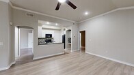This single-story, 2-bedroom, 2-bathroom home offers a thoughtfully designed layout with a range of notable architectural features. Light-toned hardwood-style flooring runs throughout the main living areas, complemented by neutral gray walls and crisp white trim that create a clean, cohesive aesthetic.

The open living area is anchored by a tile-surround fireplace and features vaulted ceilings with crown molding and a ceiling fan, while multiple windows invite natural light and outdoor views. An arched passageway connects the living space to the kitchen, which is equipped with white cabinetry, dark granite countertops, black appliances, and a mosaic tile backsplash in earthy tones.

The primary bedroom is generously sized with vaulted ceilings, a ceiling fan, and a large arched window that floods the room with natural light. The second bedroom similarly benefits from vaulted ceilings and good natural light. Both bathrooms are finished in neutral tones, with one featuring a tiled tub-shower surround and white vanity cabinetry. Additional conveniences include a dedicated laundry area, two closets, and a carpeted interior staircase.