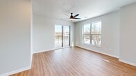This contemporary 1040 square foot apartment offers a harmonious blend of comfort and style. The open-concept layout seamlessly integrates the living room and kitchen, creating an inviting space for both relaxation and entertaining. The kitchen is a chef's delight, boasting light wood cabinetry, stainless steel appliances, and a generous central island, all accented by subway tile backsplash.

Large windows and sliding glass doors flood the space with natural light, while providing access to a private balcony offering scenic views. The apartment features two bedrooms, including a spacious 190 square foot primary bedroom, and two well-appointed bathrooms. One bathroom showcases a modern vanity with ample storage and stylish lighting.

Throughout the apartment, warm wood-look flooring adds a touch of elegance, contrasting beautifully with the crisp white walls. Plush carpeting in the bedrooms ensures comfort underfoot. The unit also includes a convenient in-unit laundry area and additional storage spaces.

Thoughtful details such as recessed lighting, ceiling fans, and modern fixtures enhance the overall ambiance. Located at 305 West Wolf River Ave in New London, WI, this apartment combines contemporary design with practical living spaces, making it an ideal home for those seeking a modern urban lifestyle.