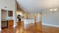Located at 635 Championship Dr in Victor, NY, this two-story home offers a generous and well-distributed floor plan across two levels, plus an unfinished basement ready for customization. The main level centers around an open-concept kitchen and living area highlighted by soaring vaulted ceilings and warm hardwood flooring throughout. The kitchen is equipped with stainless steel appliances, white shaker-style cabinetry, granite countertops, and a central island with a sink — ideal for both everyday living and entertaining. Recessed lighting and a chandelier in the living area enhance the bright, airy atmosphere. The two bedrooms feature plush carpeting and neutral tones, offering comfortable, well-sized retreats. The primary bedroom provides a generous footprint suited for a full furniture arrangement. Both bathrooms are thoughtfully appointed; one features tile flooring, a sliding glass walk-in shower with tile surround, and a white vanity. A dedicated laundry room includes a side-by-side washer and dryer with overhead cabinetry and a folding counter. The expansive unfinished basement presents significant potential for additional living space, with multiple windows allowing natural light and a full HVAC system already in place.