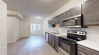 Located at 2004 Prairie Rose Dr in Mankato, Minnesota, this efficiently designed single-floor unit makes smart use of its compact footprint. The open-concept kitchen and living area serves as the heart of the space, finished with light wood-look luxury vinyl plank flooring that runs throughout and contributes to a clean, cohesive aesthetic. The kitchen is well-appointed with dark-toned cabinetry, light countertops, and a full suite of stainless steel appliances including a refrigerator with ice and water dispenser, electric range, built-in microwave, and dishwasher. A double-basin sink sits beneath upper cabinets, maximizing storage and functionality. The living area benefits from a window that allows natural light to fill the space, creating an open and inviting atmosphere. The bathroom features a tub-shower combination, a single vanity with a mirror and overhead lighting, and consistent vinyl plank flooring. Additional utility and laundry areas provide practical in-unit conveniences. The unit's neutral wall tones, white trim, and modern fixtures throughout give it a fresh, move-in-ready feel well-suited for efficient everyday living.