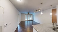 This single-story residence in Austin, TX offers three bedrooms and two bathrooms within a thoughtfully designed floor plan. The open-concept kitchen and living area serves as the heart of the home, featuring rich dark hardwood-style flooring, a granite-topped kitchen island with pendant lighting, warm wood cabinetry, stainless steel appliances, and a track lighting system. A ceiling fan overhead and French doors leading to an outdoor area allow for natural light and ventilation throughout the main living space.

The primary bedroom features hardwood-style flooring, a ceiling fan, and direct access to a bathroom and a dedicated closet equipped with wire shelving systems for organized storage. The two additional bedrooms are finished with plush carpet flooring, ceiling fans, and windows that invite natural light and outdoor views. Each bedroom offers a comfortable and functional layout suitable for various uses.

The bathrooms are finished with wood-toned vanity cabinetry, white countertops, wide mirrors, and contemporary lighting fixtures. A hallway connects the bedrooms and bathrooms, providing a logical flow throughout the residence. The clean, neutral color palette and consistent finishes create a cohesive and move-in-ready living environment.