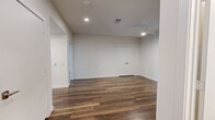This well-appointed 2-bedroom, 4-bathroom single-story home offers a clean, modern aesthetic throughout its generously sized floor plan. The open-concept kitchen and living area serves as the heart of the home, featuring rich hardwood-style flooring, recessed lighting, and large windows that invite abundant natural light and outdoor views. The kitchen is outfitted with sleek flat-front cabinetry in a warm wood tone, stainless steel appliances including a gas range, built-in microwave, and French door refrigerator, complemented by a large quartz waterfall island with an undermount sink. The adjacent living room is spacious and bright, complete with a ceiling fan and additional recessed lighting. Both bedrooms are well-sized and carpeted for comfort, each equipped with ceiling fans. The generously proportioned primary bedroom includes access to a spa-like ensuite bathroom featuring a dual-sink vanity with quartz countertops, wood cabinetry, large-format marble-look tile flooring, a soaking tub, and a glass-enclosed shower. Multiple walk-in closets with built-in shelving and hanging rods provide ample storage. A dedicated laundry room houses a full-size washer and dryer. The home also includes a patio, utility room, and two hallways connecting the thoughtfully arranged spaces.