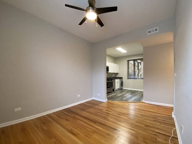 Sala de estar con pisos de madera y un ventilador de techo - 2801 W Logan