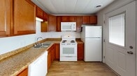 This three-floor space offers a straightforward and functional layout with a clean, neutral aesthetic throughout. The interior is characterized by white walls, wall-to-wall carpeting in tan and beige tones across multiple rooms, and windows fitted with horizontal blinds that allow natural light to fill each space.

The rooms across the floors are generously sized and open, offering a blank canvas well-suited for a variety of uses. Several rooms feature panel-style ceilings and built-in closet or wall panel systems, adding practical storage potential. Textured ceilings are present in some areas, while others feature smooth paneled finishes, giving each floor a slightly distinct character.

The kitchen stands out as the most finished space, equipped with rich, warm-toned wood cabinetry, granite-look countertops, and a full suite of white appliances including a refrigerator, electric range, over-the-range microwave, and dishwasher. Light wood-style flooring in the kitchen contrasts with the carpeted areas throughout the rest of the property.

A staircase with wooden treads connects the floors, as seen in the dollhouse overview. The overall ambiance is clean, minimal, and move-in ready, providing a versatile foundation for residential or office use. Natural light from multiple windows brightens the interior across all levels.